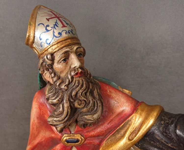 Zbliżenie na profil twarzy brodatego świętego w rzeźbionej mitrze z widocznymi detalami polichromii.