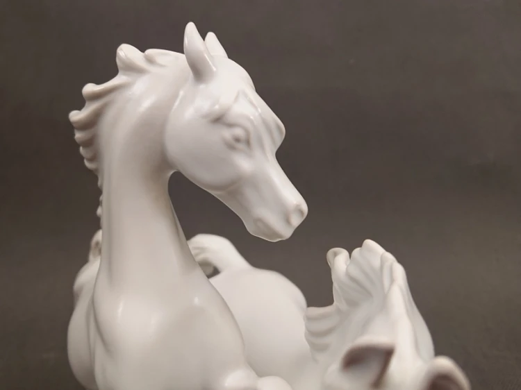 Zbliżenie na głowę i grzywę białego konia z porcelany Goebel, widoczne precyzyjne modelowanie detali i błysk szkliwa.