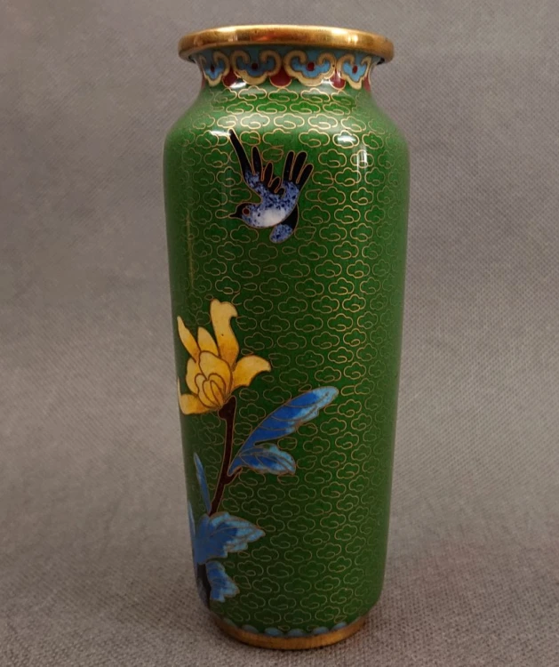 Fragment chińskiego wazonu cloisonne przedstawiający misternie wykonaną jaskółkę w locie wśród motywów roślinnych.