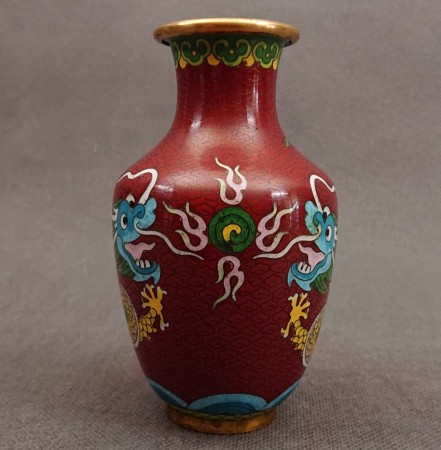 Frontowy kadr wazonu cloisonne ukazujący detale głowy chińskiego smoka z otwartą paszczą oraz symetrycznie ułożone chmury.