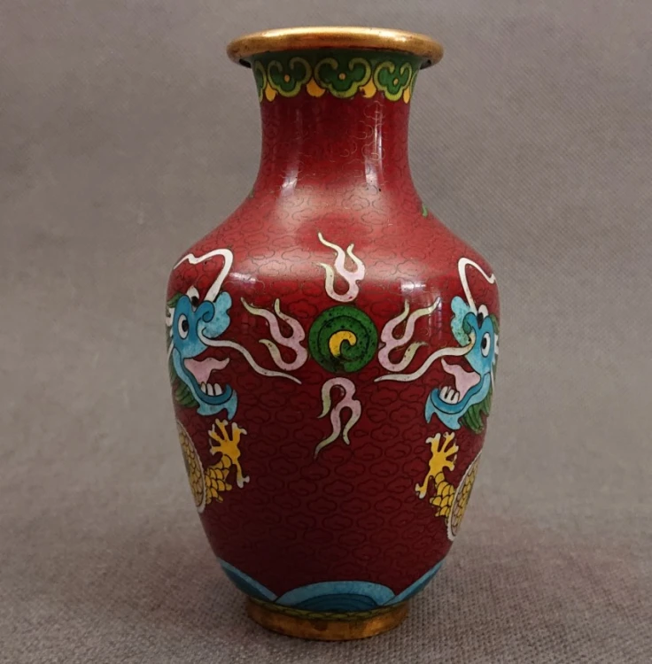 Frontowy kadr wazonu cloisonne ukazujący detale głowy chińskiego smoka z otwartą paszczą oraz symetrycznie ułożone chmury.