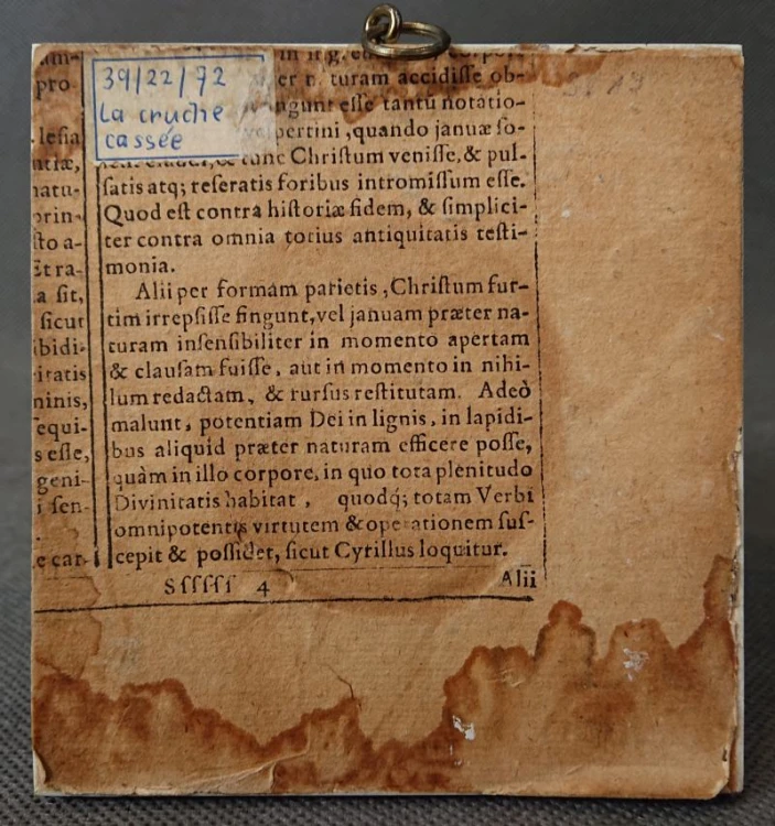 Odwrotna strona kwadratowej miniatury, widoczny podkład z dawnego druku łacińskiego z brązowymi zaciekami od wilgoci u dołu oraz odręczny wpis atramentem La cruche cassée w lewym górnym rogu.