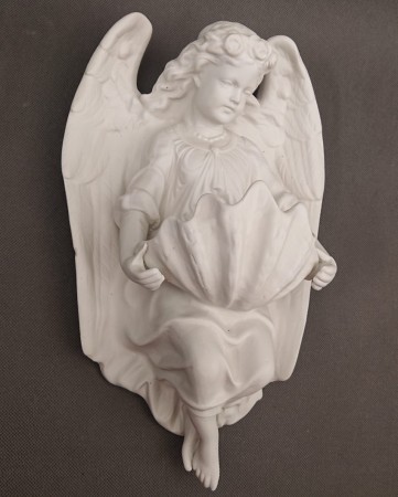 Porcelanowa kropielnica ścienna w ujęciu z lewej strony, podkreślająca precyzyjną strukturę piór na skrzydłach oraz ułożenie szat.