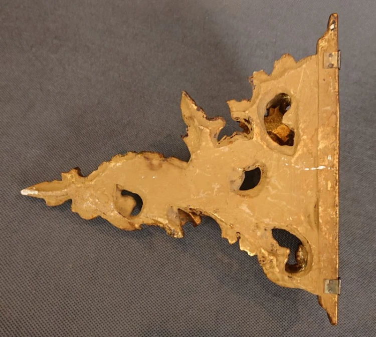 Gładka, złocona góra blatu półeczki o szerokości 20,5 cm i głębokości 12,5 cm z widocznymi krawędziami uszek montażowych.