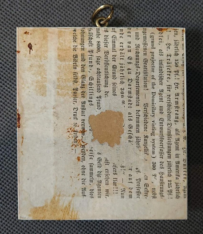 Tył miniatury portretowej z widocznym uszkiem do zawieszenia oraz podkładem zabezpieczającym z epoki.