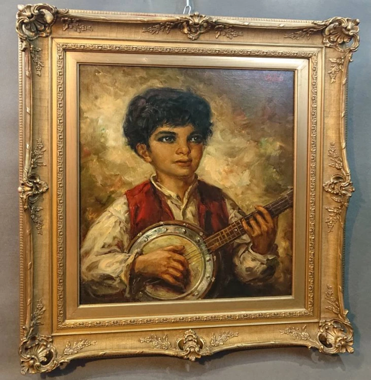 Portret chłopca grającego na banjo ujęty pod lekkim kątem z lewej strony w sztukateryjnej ramie