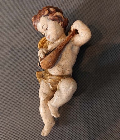 Rzeźbiony aniołek muzykujący ujęcie z prawego profilu