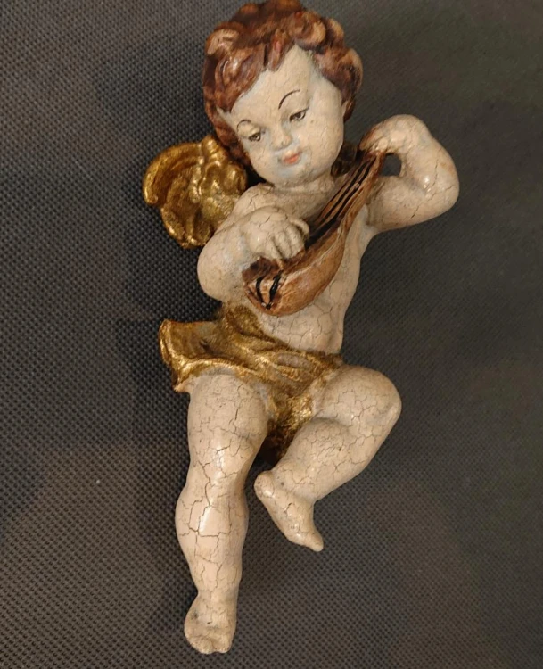 Aniołek grający na mandolinie na szarym tle ujęcie pod kątem
