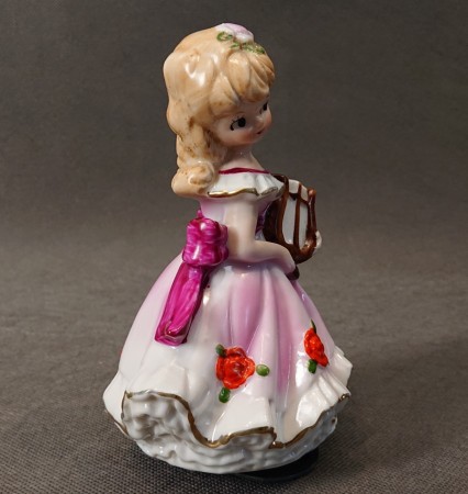 Porcelanowa figurka lady z harfą w różowej sukni widok z prawego boku